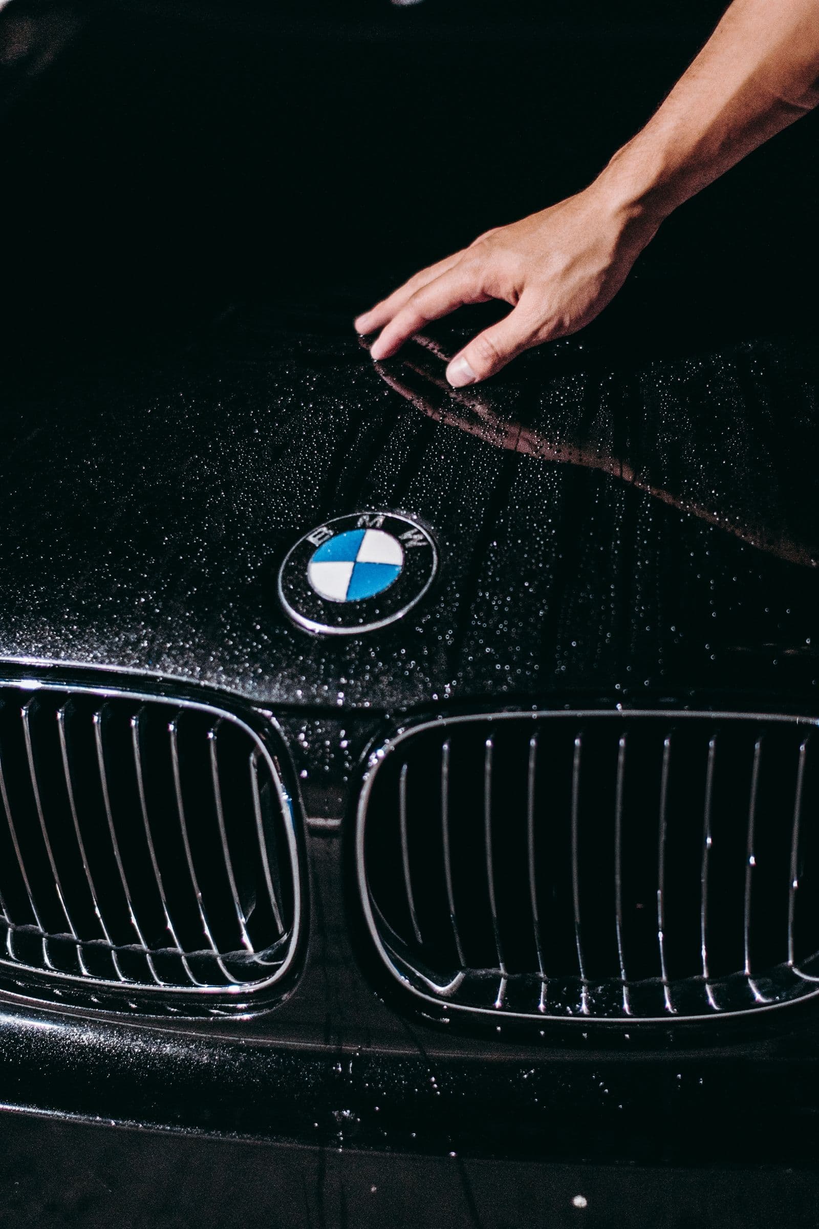 Water beading on the spotless hood of a detailed black sedan