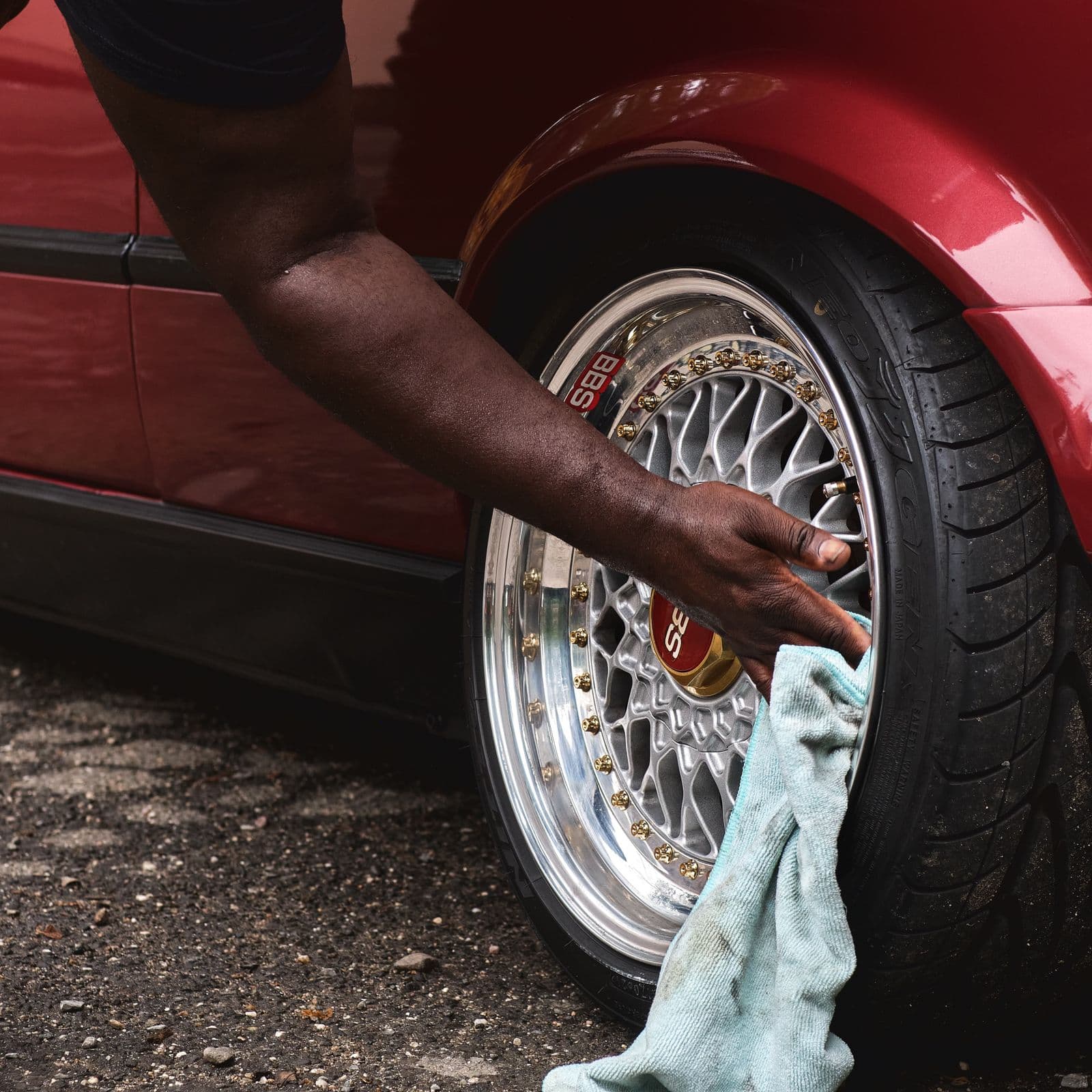 Mirror-polished wheel against the glossy paint of a finished red car