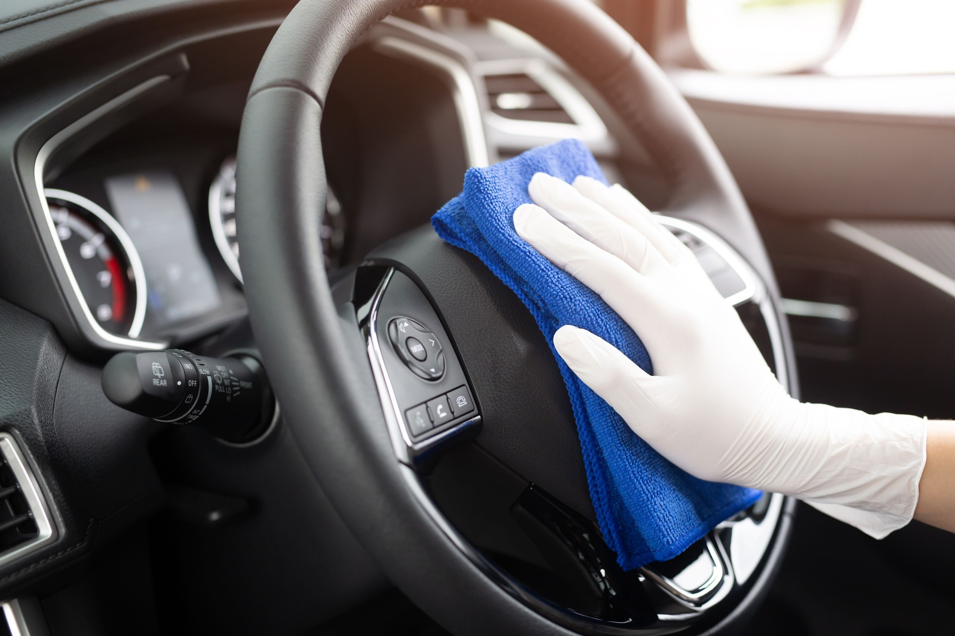 worker man wear gloves cleaning car interior console with microfiber cloth, detailing, car wash service concept. copy space.